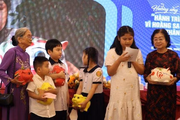 Các học sinh và gia đình đập heo đất ủng hộ biển đảo.