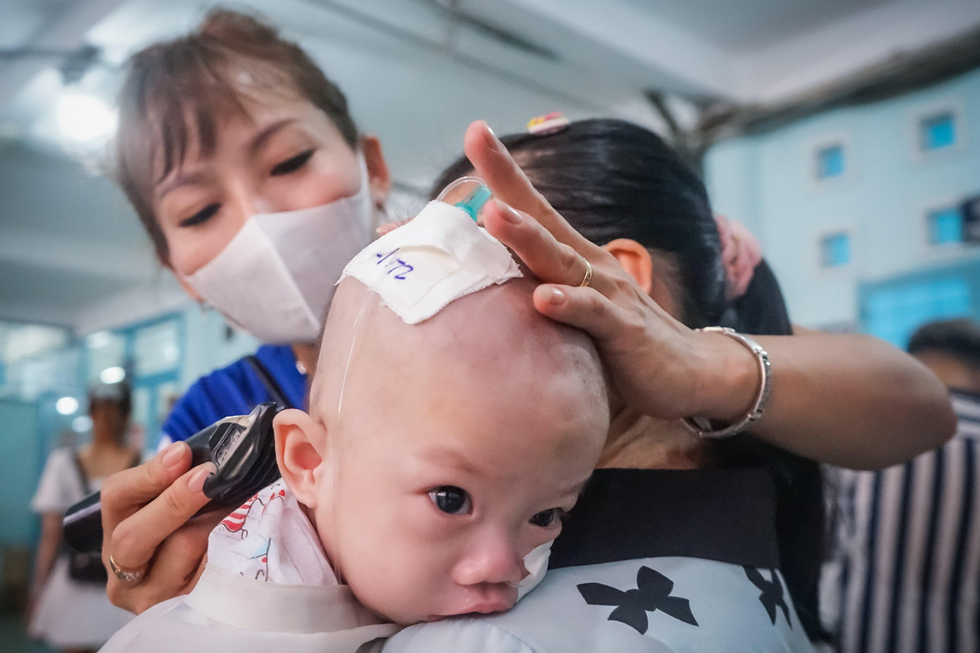 Một em bé được ba mẹ đưa xuống cắt tóc.