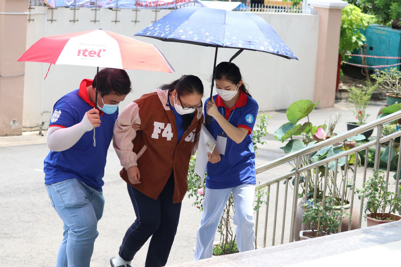 Tình nguyện viên che nắng cho các thí sinh khi các bạn vào làm thủ tục dự thi.