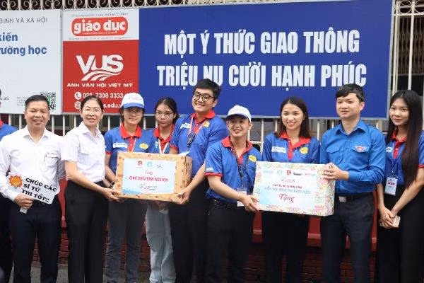 Anh Nguyễn Minh Triết (thứ hai bên phải) tận tay trao quà cho đội hình tiếp sức mùa thi điểm thi trường THCS Colette.