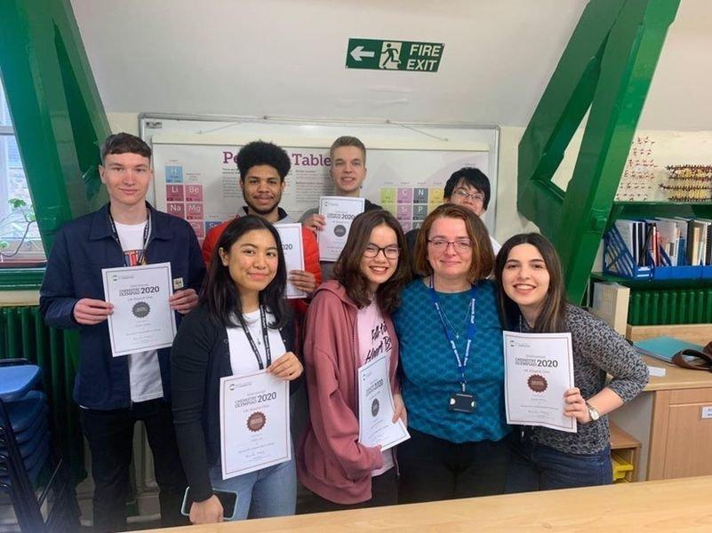 Harlie (hàng trên, thứ hai từ trái sang) cùng cô giáo và bạn bè quốc tế.