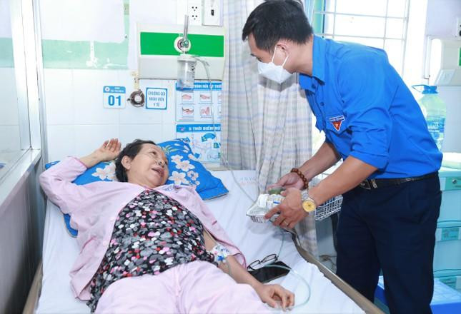 Anh Nguyễn Dũng, Bí thư Chi đoàn Ban đại diện Báo Tiền Phong tại TP. HCM tặng phần cơm và động viên người bệnh. (Ảnh: Ngô Tùng)