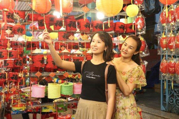 Các bạn trẻ thích thú tạo dáng chụp ảnh cùng lồng đèn.
