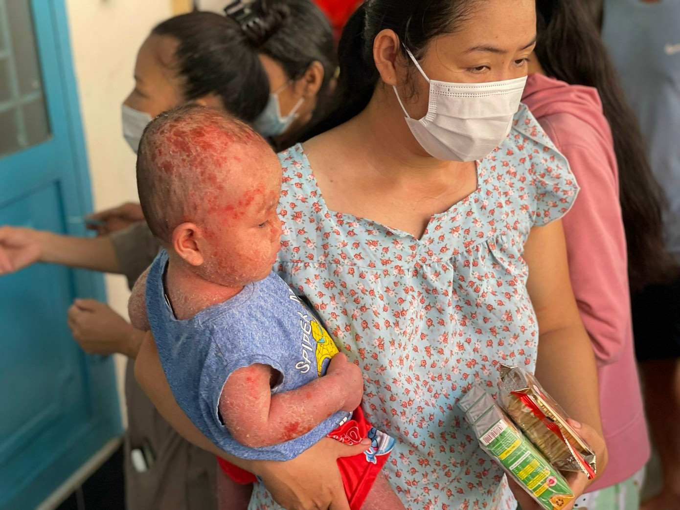 Phụ huynh bệnh nhi (Bệnh viện Nhi đồng 1) nhận quà cho các em thiếu nhi.