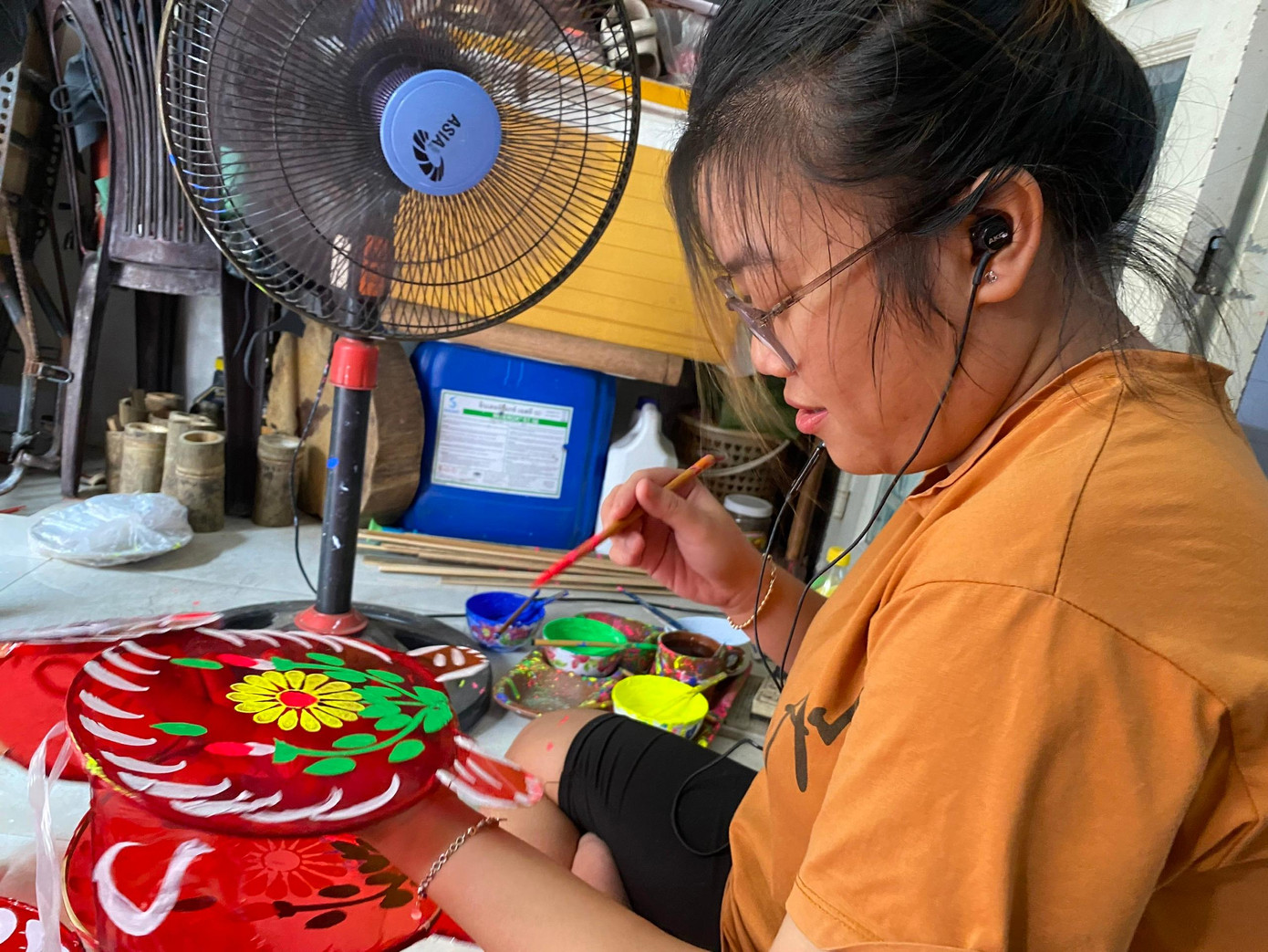 Chị Hồng Anh đảm nhận nhiệm vụ vẽ trang trí cho những chiếc lồng đèn. Công đoạn này là một trong những yếu tố tạo nên “linh hồn” cho từng chiếc lồng đèn. (Ảnh: Phước Sáng).