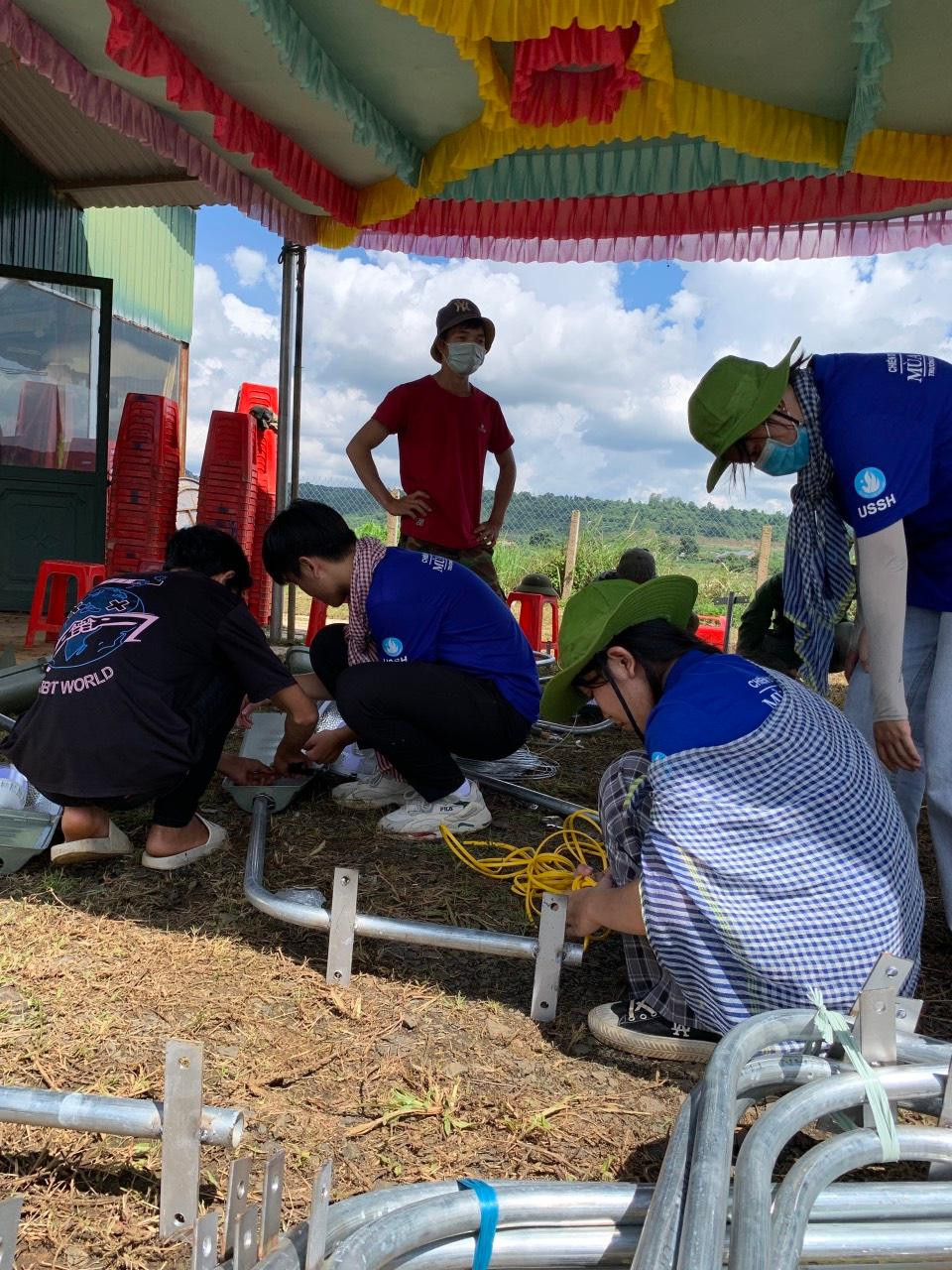 Các chiến sĩ áo xanh giúp người dân lắp đèn đường thắp sáng.