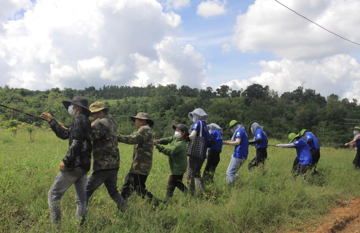 Chiến sĩ áo xanh giúp dân kéo dây điện.