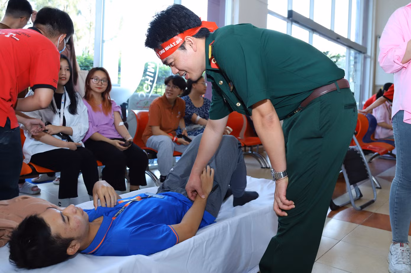 Trung tá Vũ Sơn Giang - Phó Chủ nhiệm Chính trị, Bệnh viện Quân Y 175 thăm hỏi sức khỏe và chia sẻ những lưu ý cho các bạn sinh viên sau khi hiến máu.