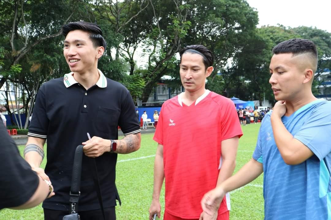 Cầu thủ Đoàn Văn Hậu (bên trái) và diễn viên Huy Khách (thứ hai bên phải) bắt tay các bạn sinh viên trước khi trận đấu giao hữu diễn ra.