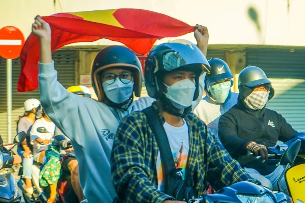 Bạn trẻ mang theo lá cờ đỏ sao vàng thể hiện sự phấn khích, niềm tự hào của dân tộc.