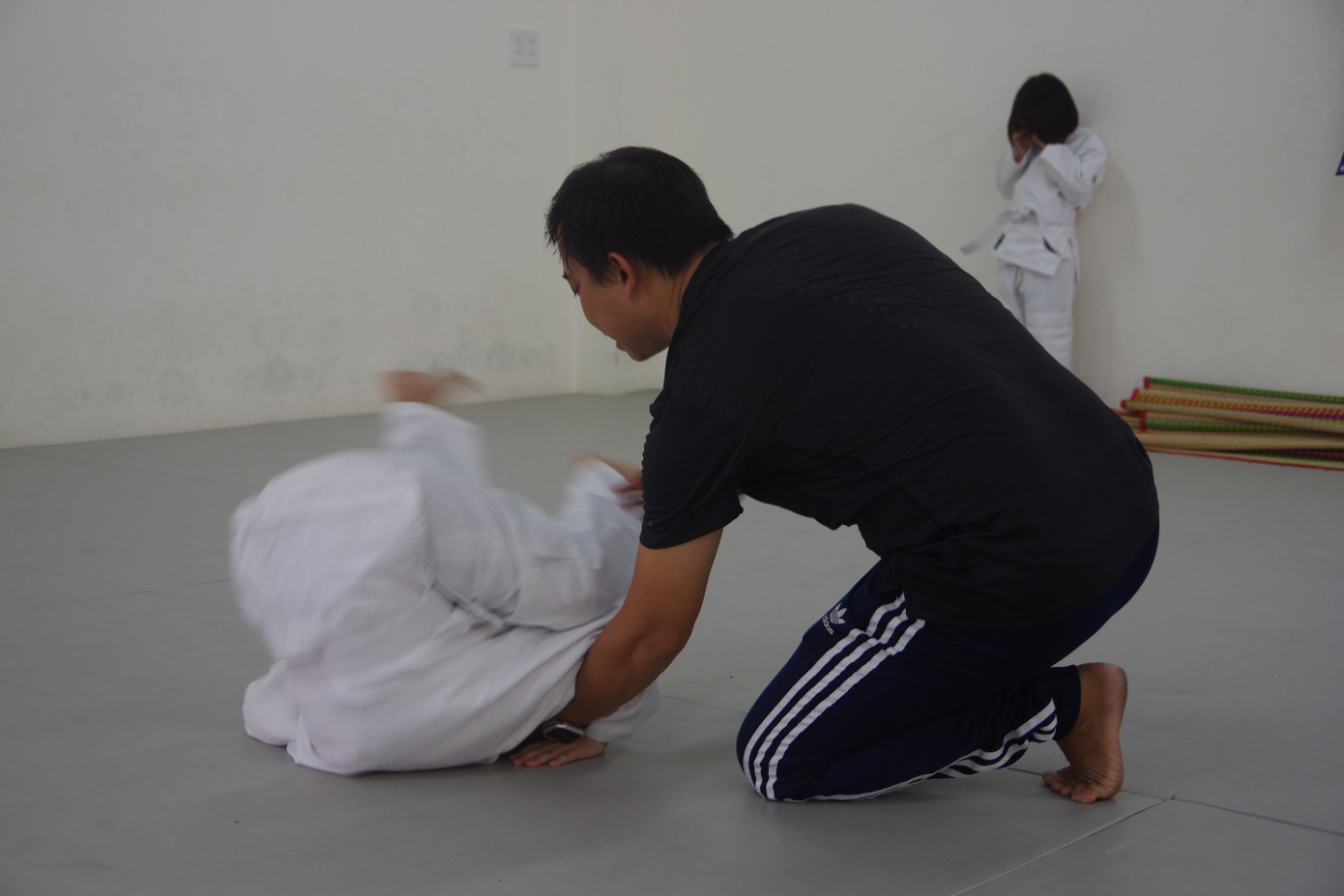 Thầy Sơn hướng dẫn học trò thực hiện động tác cuộn tròn về phía trước.