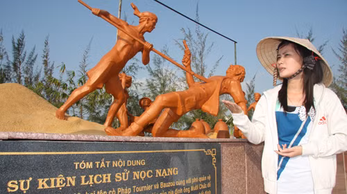 Nhân viên khu di tích Nọc Nạng giới thiệu với khách tham quan về trận quyết tử của gia đình ông Mười Chức năm 1928 được tái hiện qua mô hình. Ảnh: Chí Quốc