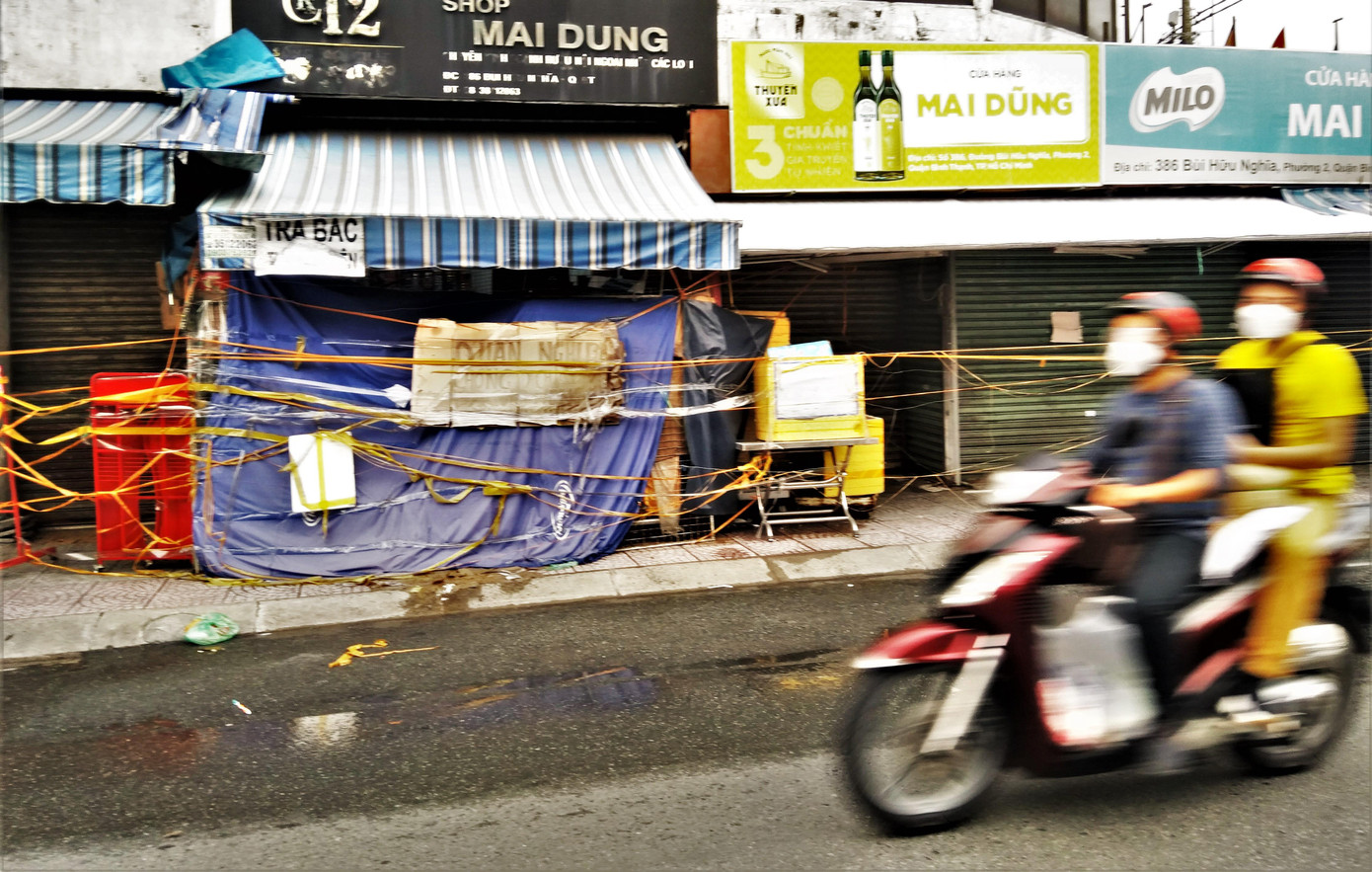 Ngày 14/9/2021, TPHCM đã xin ý kiến Thủ tướng Chính phủ và được thống nhất về tiếp tục thực hiện giãn cách thêm 2 tuần theo tinh thần Chỉ thị 16. Lý do là nhiều địa phương chưa đạt các tiêu chí kiểm soát dịch và TPHCM cần phấn đấu tiếp tục thực hiện giãn cách trong thời gian tới. Người dân TPHCM tiếp tục giãn cách ở mức độ cao, nhằm bảo vệ sự an toàn cho gia đình và khu dân cư, giảm số ca nhiễm mới, phấn đấu kiểm soát dịch bệnh COVID-19. Trong ảnh: Cửa hàng bán sữa gần chợ Bà Chiểu (quận Bình Thạnh) bên trong vẫn bật đèn sáng, nhưng bên ngoài được "bọc" kín. Ngày 14/9/2021, TPHCM đã xin ý kiến Thủ tướng Chính phủ và được thống nhất về tiếp tục thực hiện giãn cách thêm 2 tuần theo tinh thần Chỉ thị 16. Lý do là nhiều địa phương chưa đạt các tiêu chí kiểm soát dịch và TPHCM cần phấn đấu tiếp tục thực hiện giãn cách trong thời gian tới. Người dân TPHCM tiếp tục giãn cách ở mức độ cao, nhằm bảo vệ sự an toàn cho gia đình và khu dân cư, giảm số ca nhiễm mới, phấn đấu kiểm soát dịch bệnh COVID-19. Trong ảnh: Cửa hàng bán sữa gần chợ Bà Chiểu (quận Bình Thạnh) bên trong vẫn bật đèn sáng, nhưng bên ngoài được "bọc" kín.