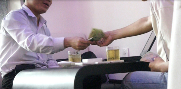 Dương Hồng Lễ (trái) đang nhận tiền một đối tác để bán dữ liệu (ảnh cơ quan an ninh cung cấp). Dương Hồng Lễ (trái) đang nhận tiền một đối tác để bán dữ liệu (ảnh cơ quan an ninh cung cấp)