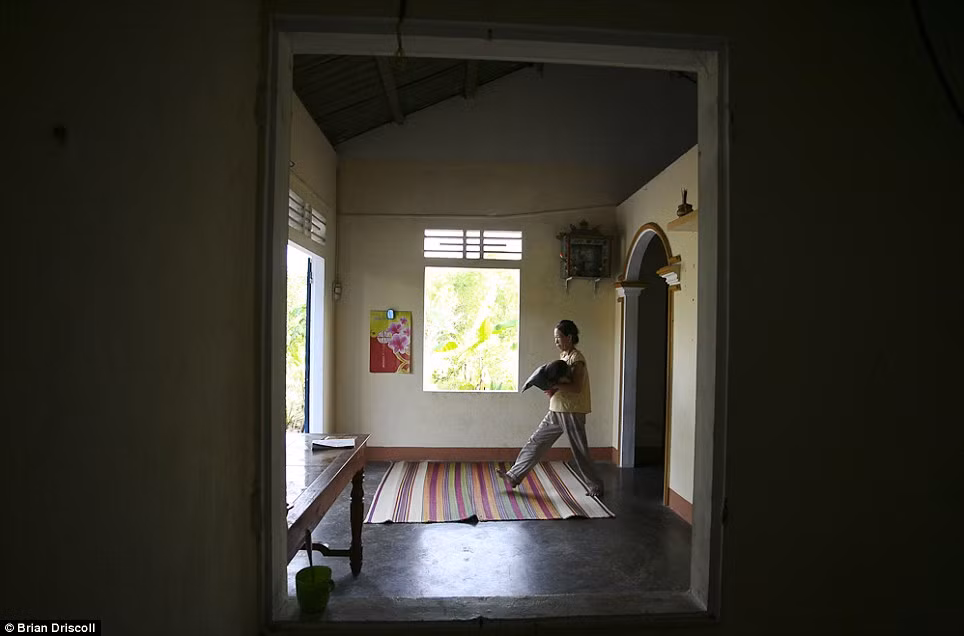 Một người mẹ ở nhà chăm sóc con đang bị ảnh hưởng bởi chất độc da cam ở Huyện Quảng Ninh