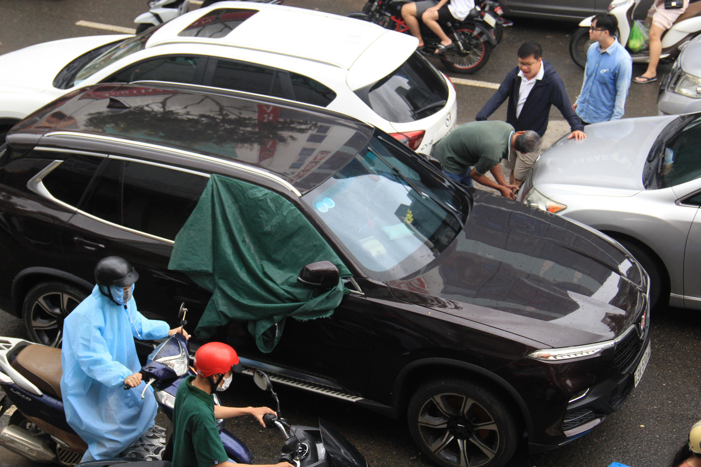 Dòng xe chen chúc trên đường khiến giao thông trở nên hỗn loạn. Người đi xe máy tìm cách len lỏi qua dòng xe đang đậu dài.