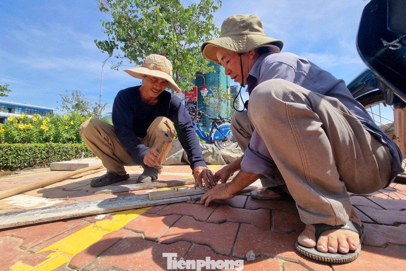 Người lao động làm việc ngoài trời dưới nắng gắt, mặt trời buổi sáng chiếu chói chang.