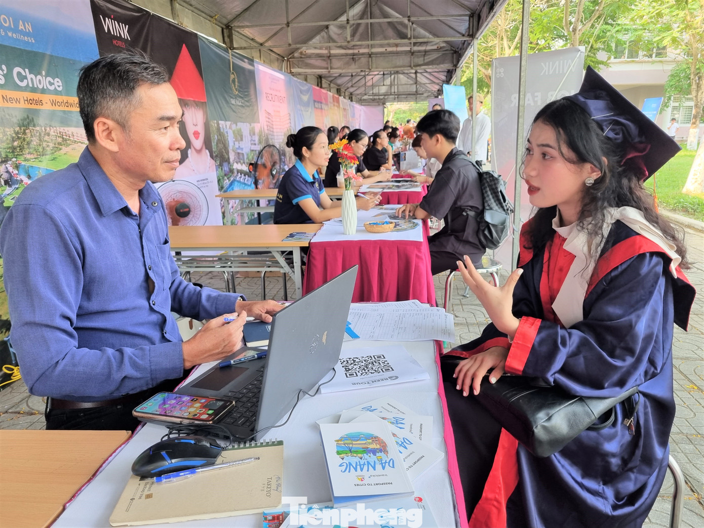 Sinh viên vừa tốt nghiệp trao đổi trực tiếp với nhà tuyển dụng, tìm kiếm cơ hội việc làm.