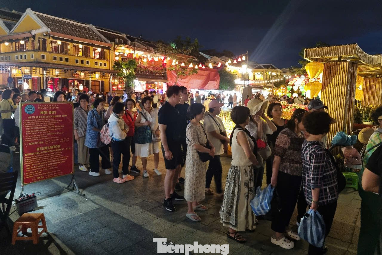 Du khách xếp hàng dài tại điểm bán vé để được xuống thuyền. Từ 16h, các thuyền chở khách bắt đầu hoạt động. Chỉ mở cửa được chừng nửa tiếng, lượng khách đã đổ về đông nghịt. Anh Tuấn Anh - hướng dẫn viên du lịch - cho hay sau một ngày dạo chơi, các đoàn khách thường chọn không gian thoáng đãng, dễ chịu để thư giãn. Hơn nữa, thời điểm chiều tối phố cổ lên đèn nên nhìn ngắm hai bên rất đẹp. Ảnh: Thanh Hiền. Du khách xếp hàng dài tại điểm bán vé để được xuống thuyền. Từ 16h, các thuyền chở khách bắt đầu hoạt động. Chỉ mở cửa được chừng nửa tiếng, lượng khách đã đổ về đông nghịt. Anh Tuấn Anh - hướng dẫn viên du lịch - cho hay sau một ngày dạo chơi, các đoàn khách thường chọn không gian thoáng đãng, dễ chịu để thư giãn. Hơn nữa, thời điểm chiều tối phố cổ lên đèn nên nhìn ngắm hai bên rất đẹp. Ảnh: Thanh Hiền.