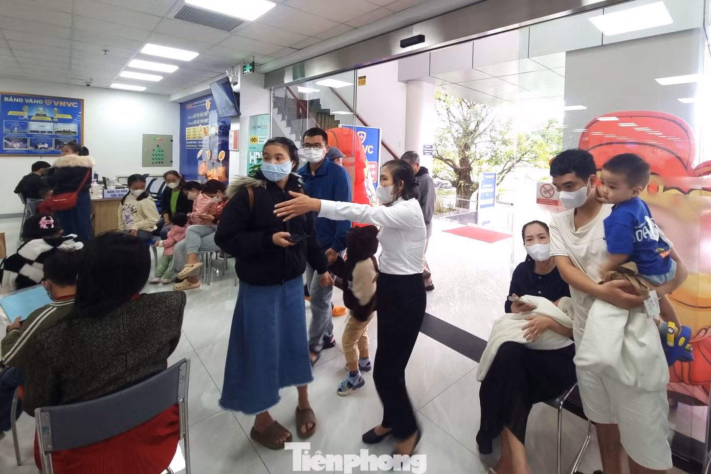 Nhân viên trung tâm tiêm chủng liên tục hướng dẫn, hỗ trợ người dân.