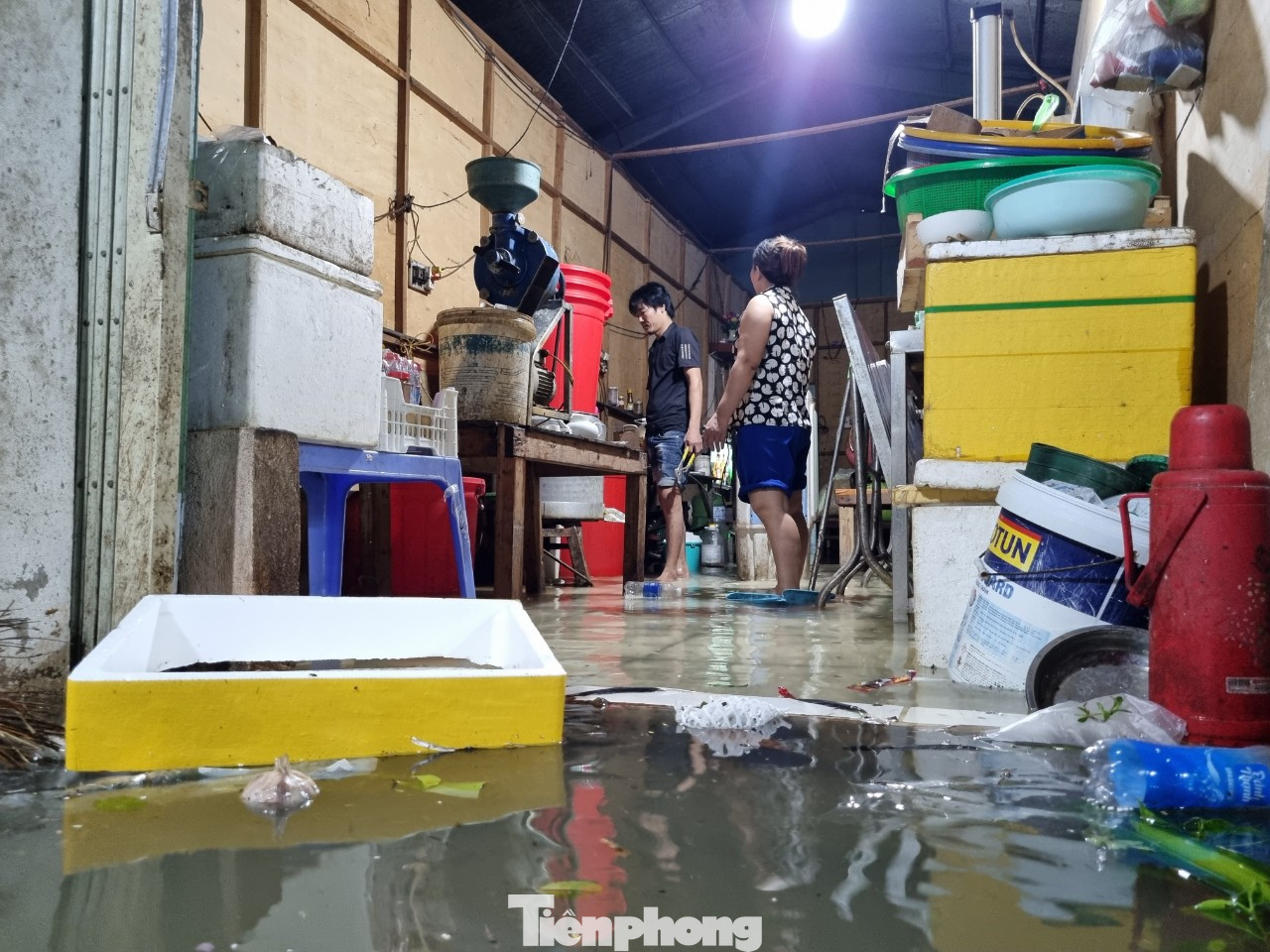 Nước tràn vào nhà dân rất nhanh. Các hộ dân tất bật cả tối dọn đồ đạc, kê gác những thiết bị điện lên để khỏi bị chập chạm.