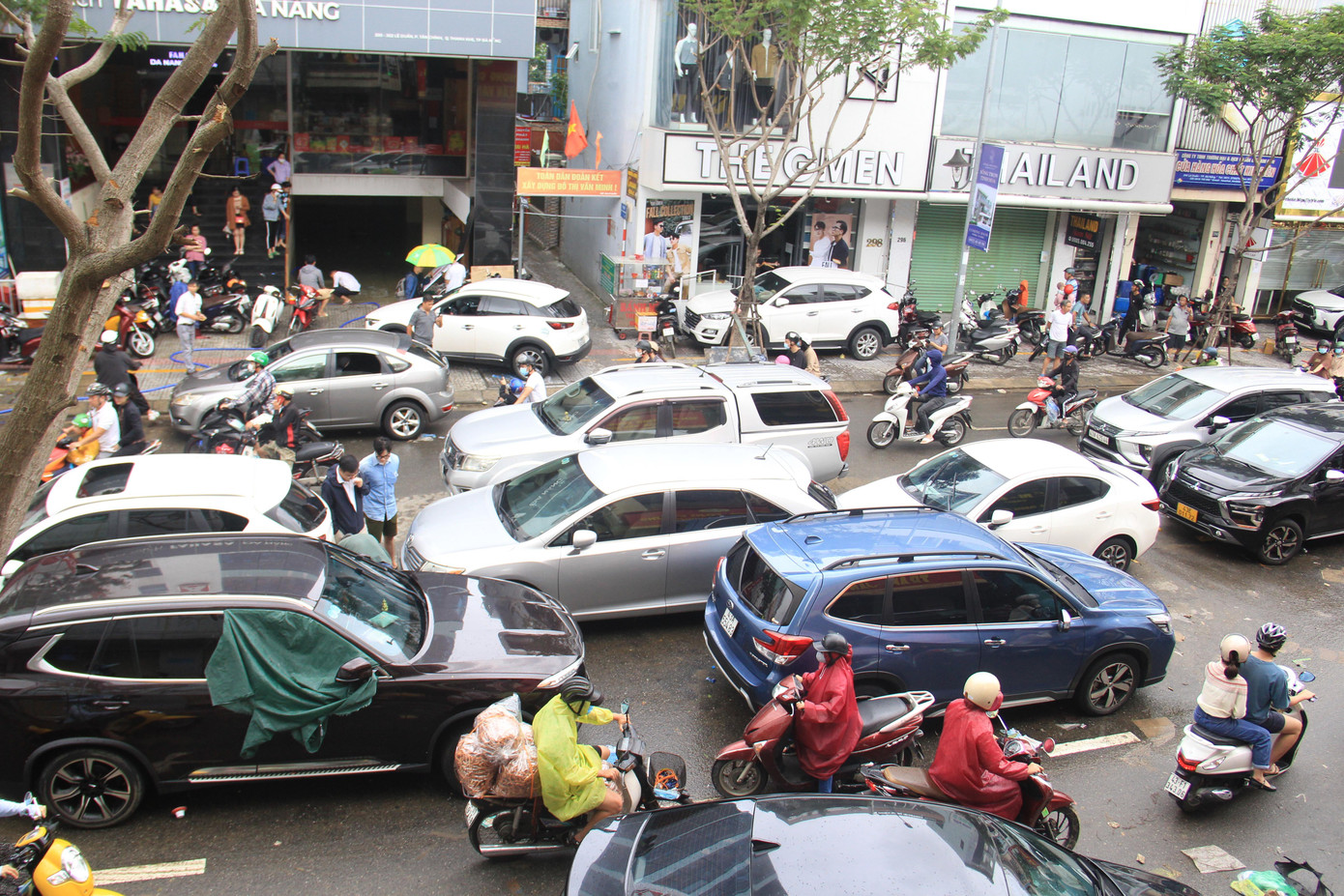 Dòng xe chen chúc trên đường khiến giao thông trở nên hỗn loạn. Người đi xe máy tìm cách len lỏi qua dòng xe đang đậu dài.