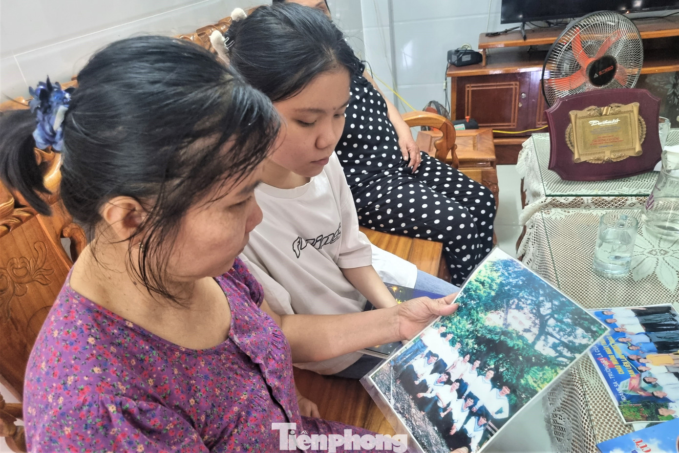 Hai mẹ con chị Lợi xem lại những bức ảnh chồng, cha chụp cùng đồng đội. Hai mẹ con chị Lợi xem lại những bức ảnh chồng, cha chụp cùng đồng đội.