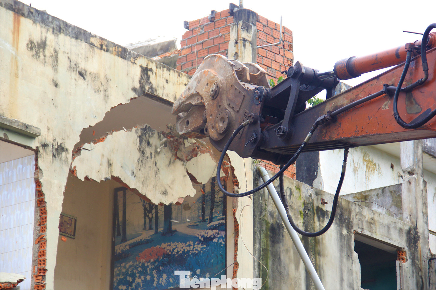 Xe múc dùng gàu đập vỡ các mảng tường, phá cốt thép các ngôi nhà.