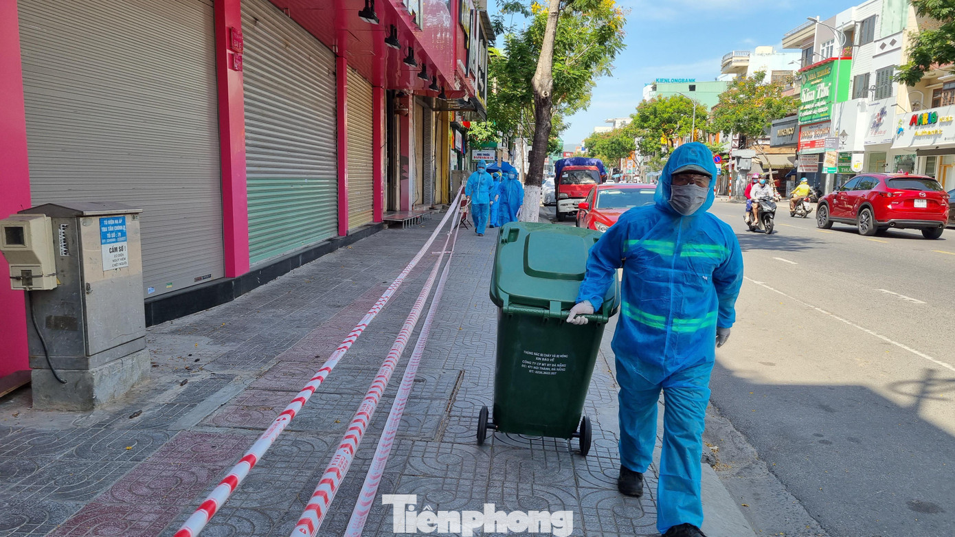 Trong bộ đồ bảo hộ, nhân viên y tế đi khắp các tuyến đường, ngõ hẻm trong khu phong tỏa. Nhiều hôm nắng lên to, đến gần trưa công việc mới hoàn thành. Ảnh: Thanh Trần.