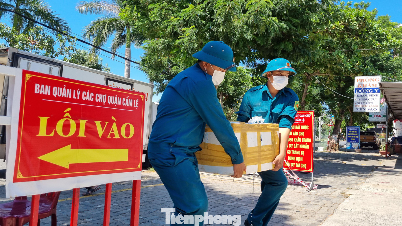 Lực lượng chức năng hỗ trợ vận chuyển thực phẩm để bán cho các tổ dân phố. Ảnh: Thanh Trần.