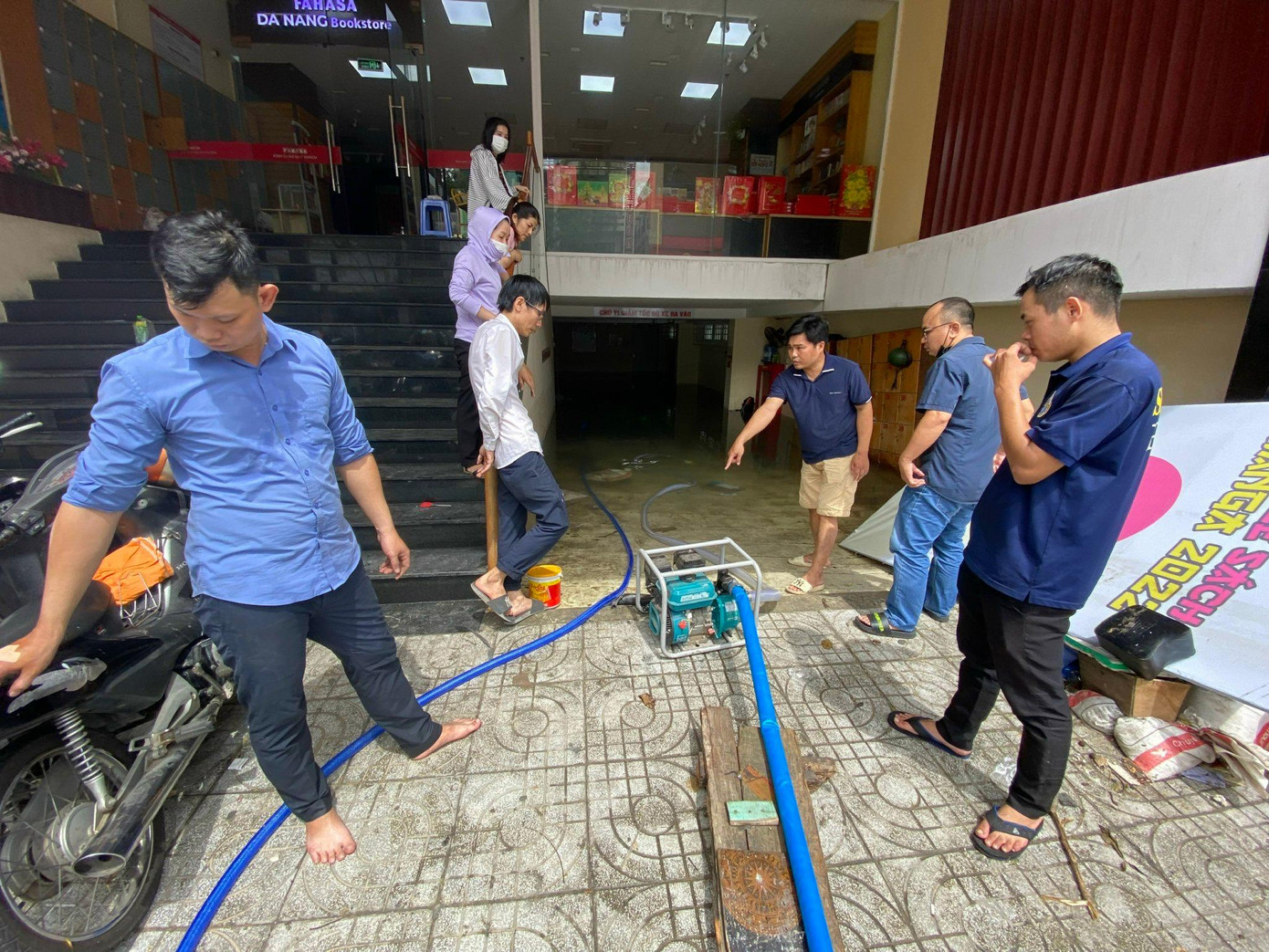 Một cửa hàng sách trên đường Lê Duẩn phải gọi máy bơm để tháo nước trong hầm. Mực nước còn hằn trên tường cho thấy hầm bị ngập rất sâu. Mực nước tính từ mặt đường lên khoảng nửa mét.