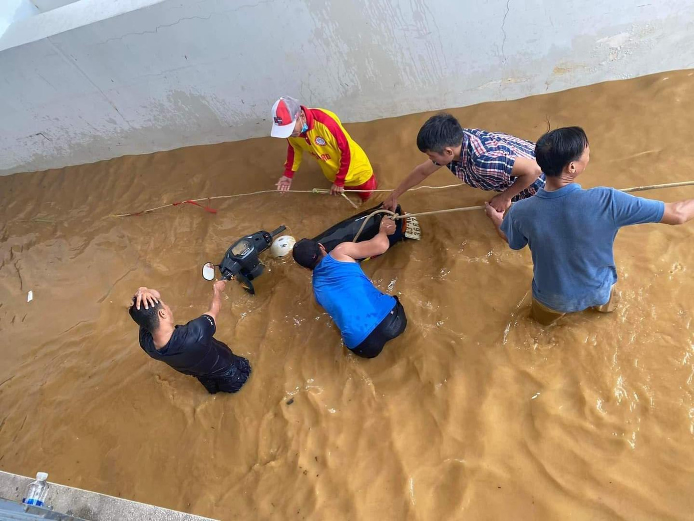 Trong khi đó, nhiều nơi không thể liên hệ được với các máy bơm, người dân đưa xe ra khỏi hầm bằng cách lặn xuống cột dây vào xe để kéo ra.