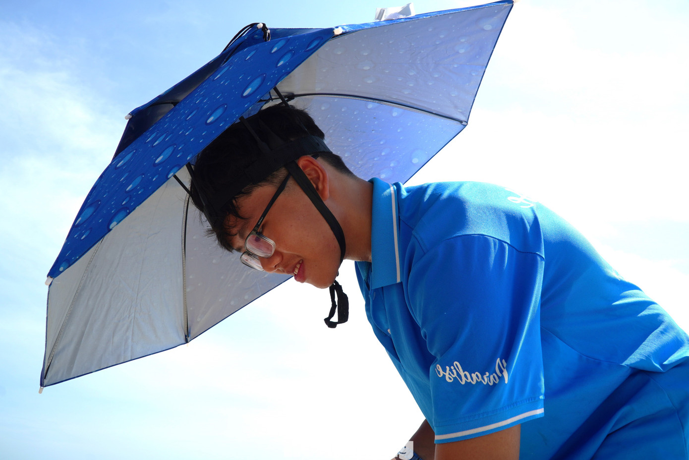 Chống chọi với &quot;chảo lửa&quot; khi làm việc ngoài trời, nhân viên một nhà hàng ven biển phải dùng ô đội đầu thay cho mũ. Theo các nhân viên, do đặc thù phục vụ du khách tắm nắng, ăn uống trên bãi cát nên họ phải ra ngoài trời liên tục. Mọi người phải dùng ô đội đầu để vừa có tán che rộng, vừa tiện lợi khi làm việc.