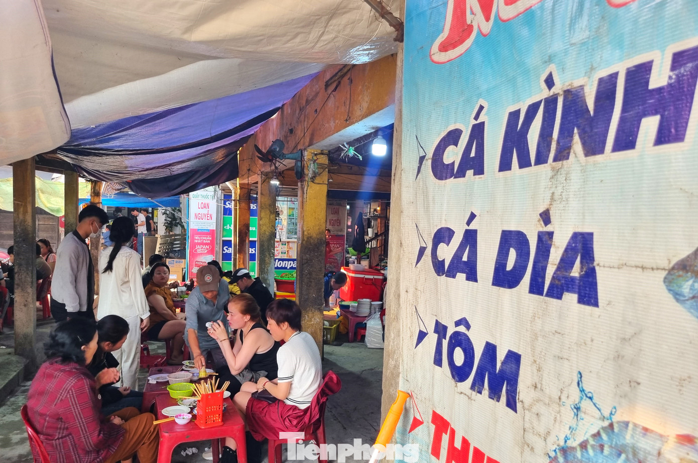 Khu chợ nhỏ xập xệ này có nhiều hàng bán bánh xèo tôm, trứng, thịt, mực, nhưng hút khách nhất là bánh xèo cá kình, cá dìa được đánh bắt từ đầm phá. Ảnh: Thanh Hiền.