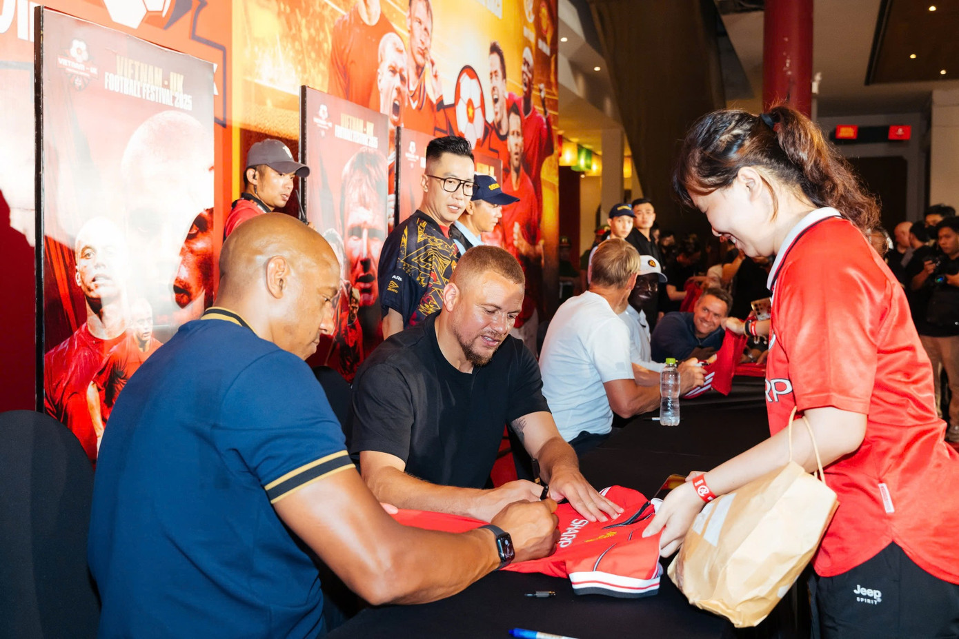 Fan MU đi xin chữ kí hai lần nhưng vẫn không đủ 3 chữ kí như quyền lợi khi mua vé. Trong ảnh: Một fan MU xin chữ kí tối 26/6. Ảnh: BTC.