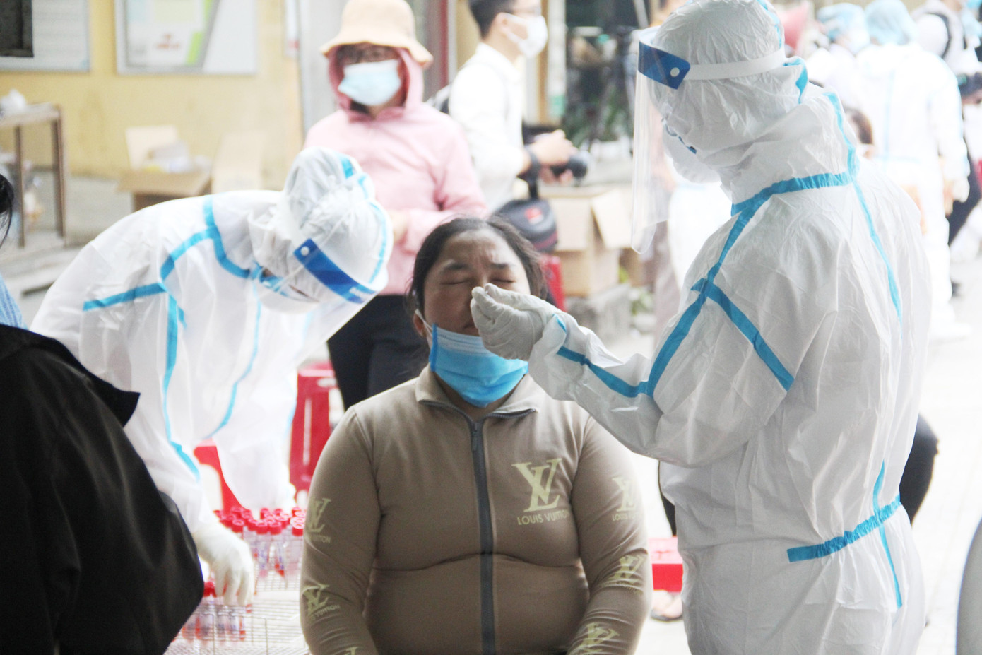 Nhân viên y tế lấy mẫu xét nghiệm cho khoảng 400 tiểu thương trong và ngoài chợ, các hộ dân xung quanh chợ. Ảnh: Thanh Trần.
