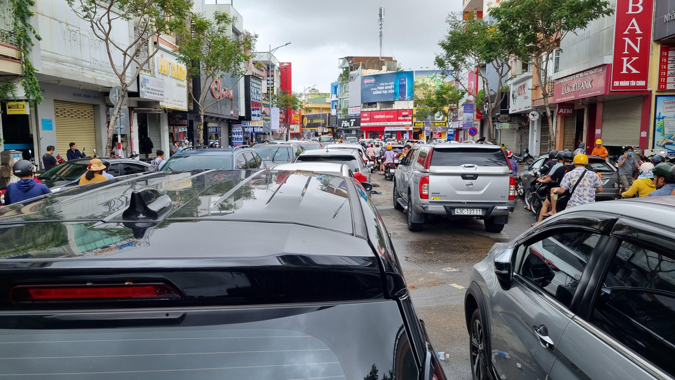 Dòng xe chen chúc trên đường khiến giao thông trở nên hỗn loạn. Người đi xe máy tìm cách len lỏi qua dòng xe đang đậu dài.