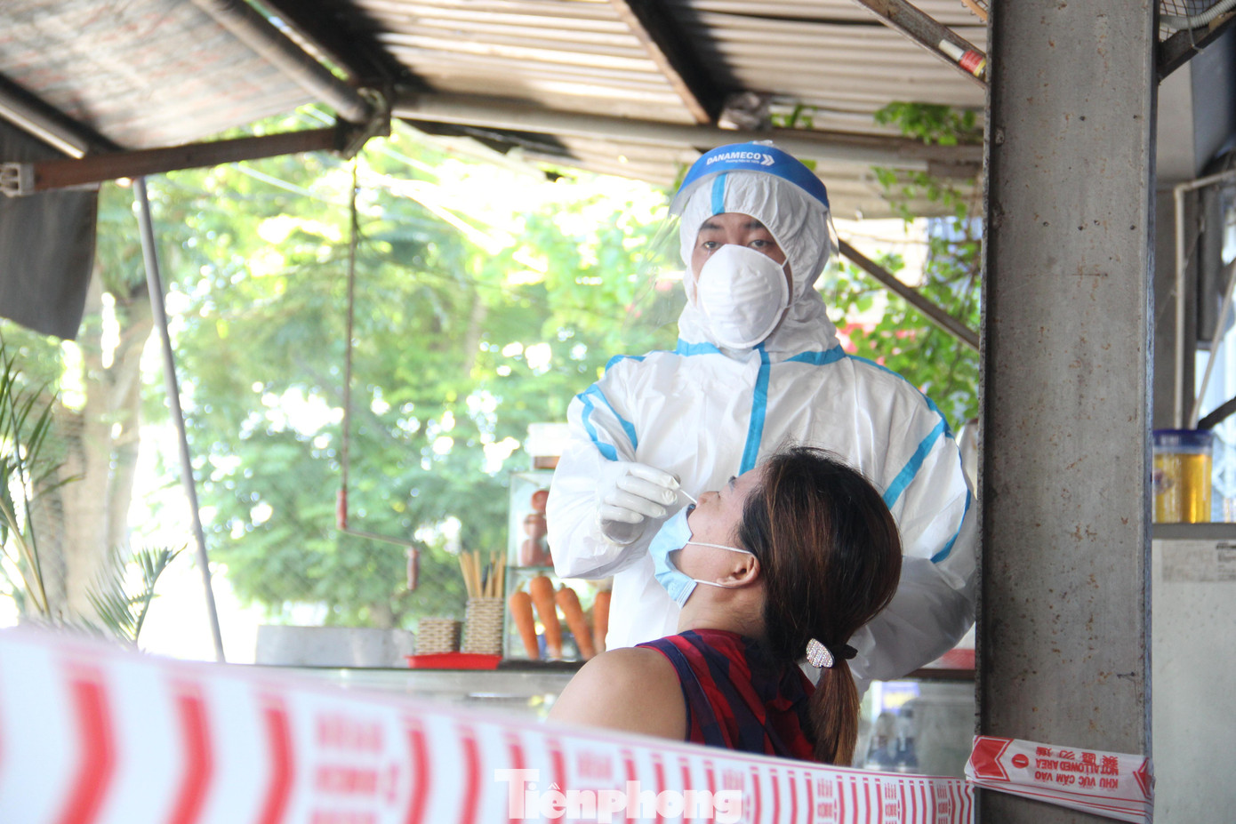 Nhân viên y tế lấy mẫu xét nghiệm cho tiểu thương chợ Hòa Cầm (quận Cẩm Lệ) sáng 14/7. Ảnh: Thanh Trần.