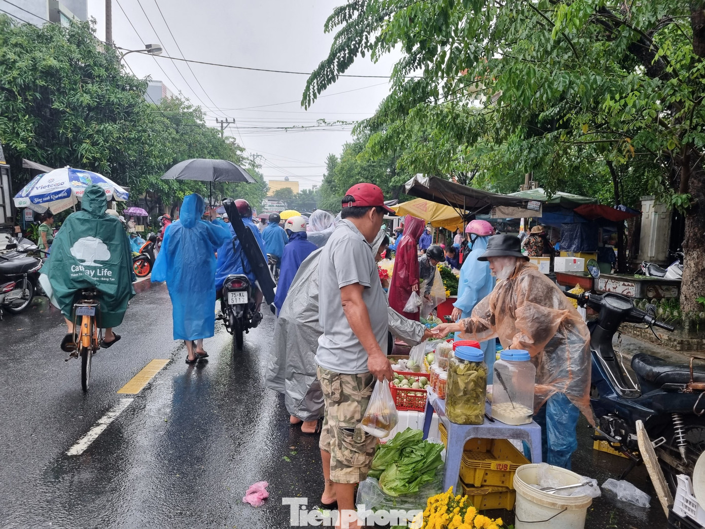 Tuyến đường gần chợ trở thành chợ dã chiến. Tiểu thương dầm mưa suốt cả ngày để bán hàng chạy ngập.
