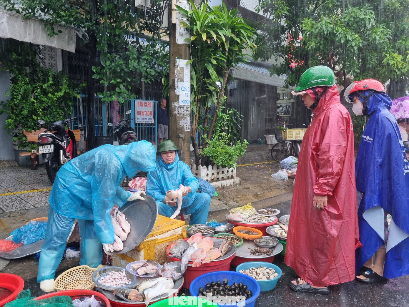 Tuyến đường gần chợ trở thành chợ dã chiến. Tiểu thương dầm mưa suốt cả ngày để bán hàng chạy ngập.