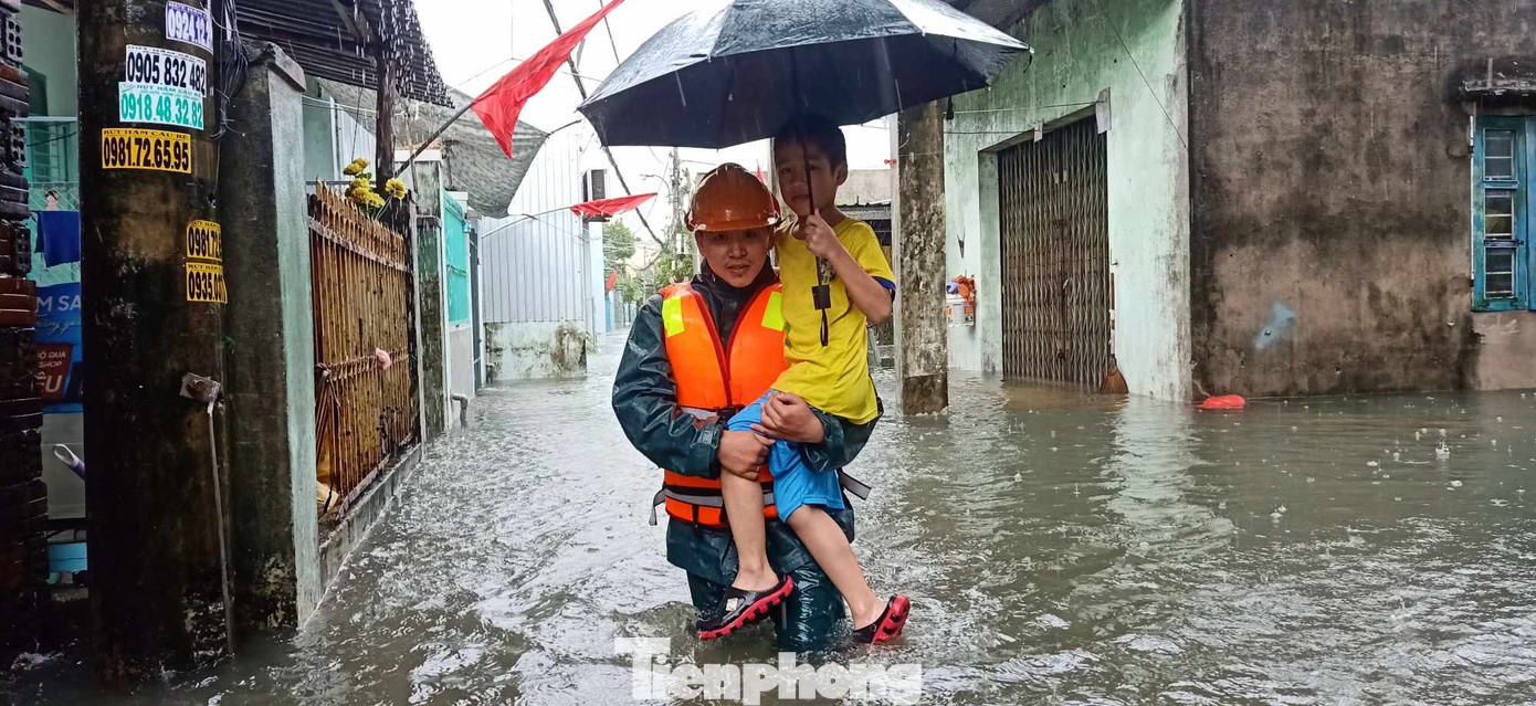 Một chiến sĩ đưa em nhỏ trong khu vực ngập sâu trong kiệt hẻm ở quận Thanh Khê đến nơi an toàn.