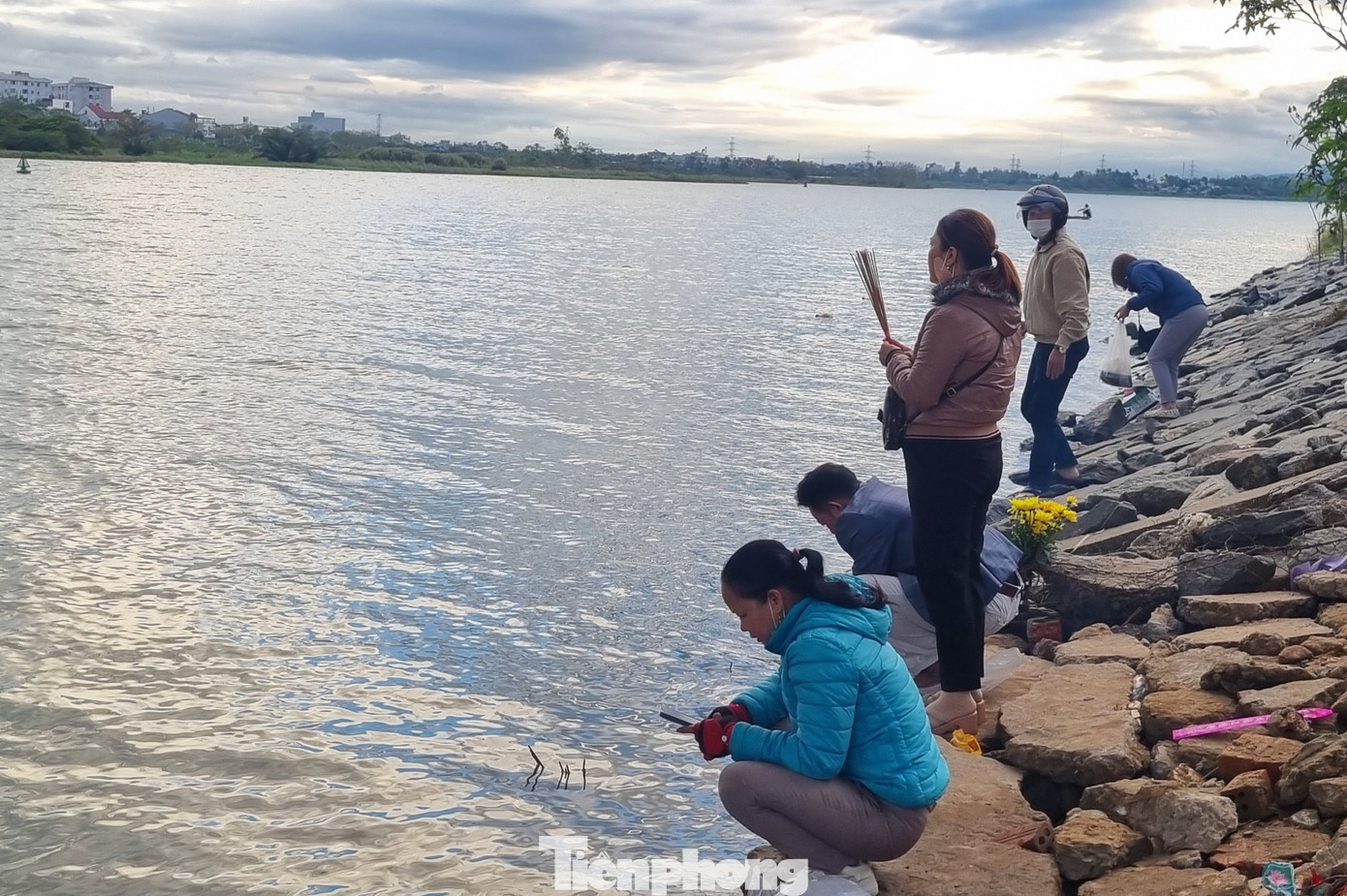 Người dân đến bên bờ sông thắp hương cầu khấn, thả cá xuống sông Cẩm Lệ. Anh Nguyễn Lộc (31 tuổi) cho hay cả ngày bận đi làm nên cuối chiều trên đường về nhà anh đã mua cá tới đây phóng sinh. "Năm nào tôi cũng ra nơi này thả cá, cầu an dịp rằm", anh nói. Ảnh: Thanh Hiền.