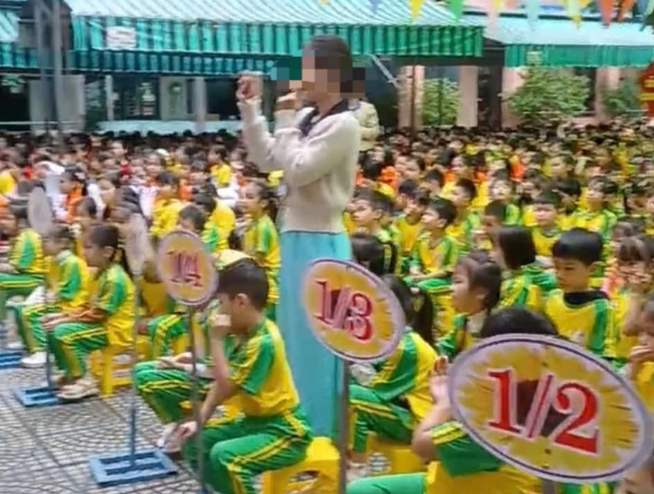 Học sinh mang đồng phục mỏng ngồi giữa sân trường trong thời tiết lạnh khiến phụ huynh bức xúc.