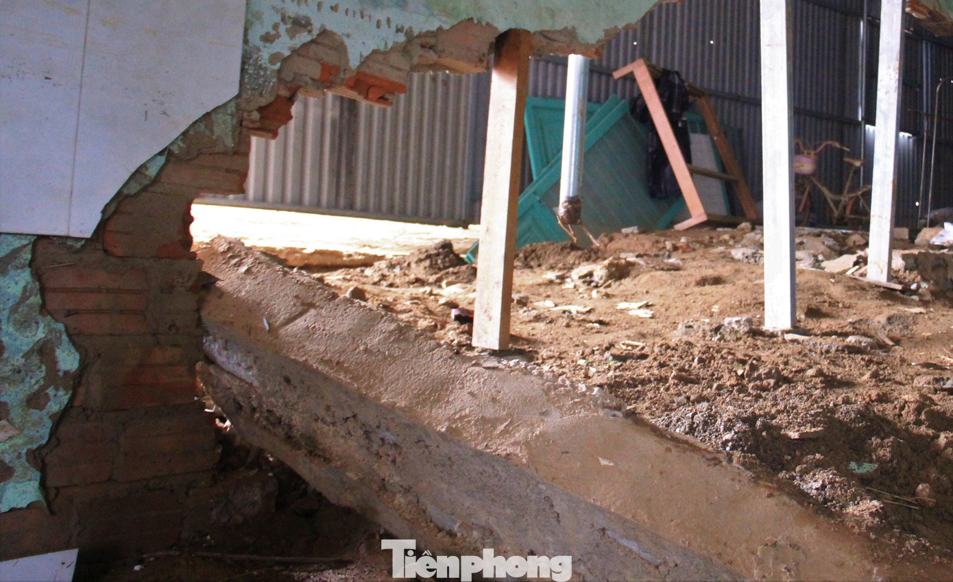 Tường sụp xuống từng mảng to, chị phải nhờ người lấy khung sắt chống đỡ để giữ phần tường còn lại không sụp xuống.