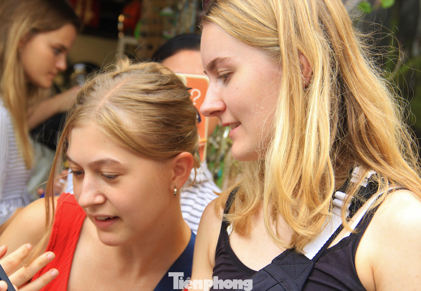 Hai nữ du khách chăm chú xem các món hàng ở quán xá trong phố cổ.