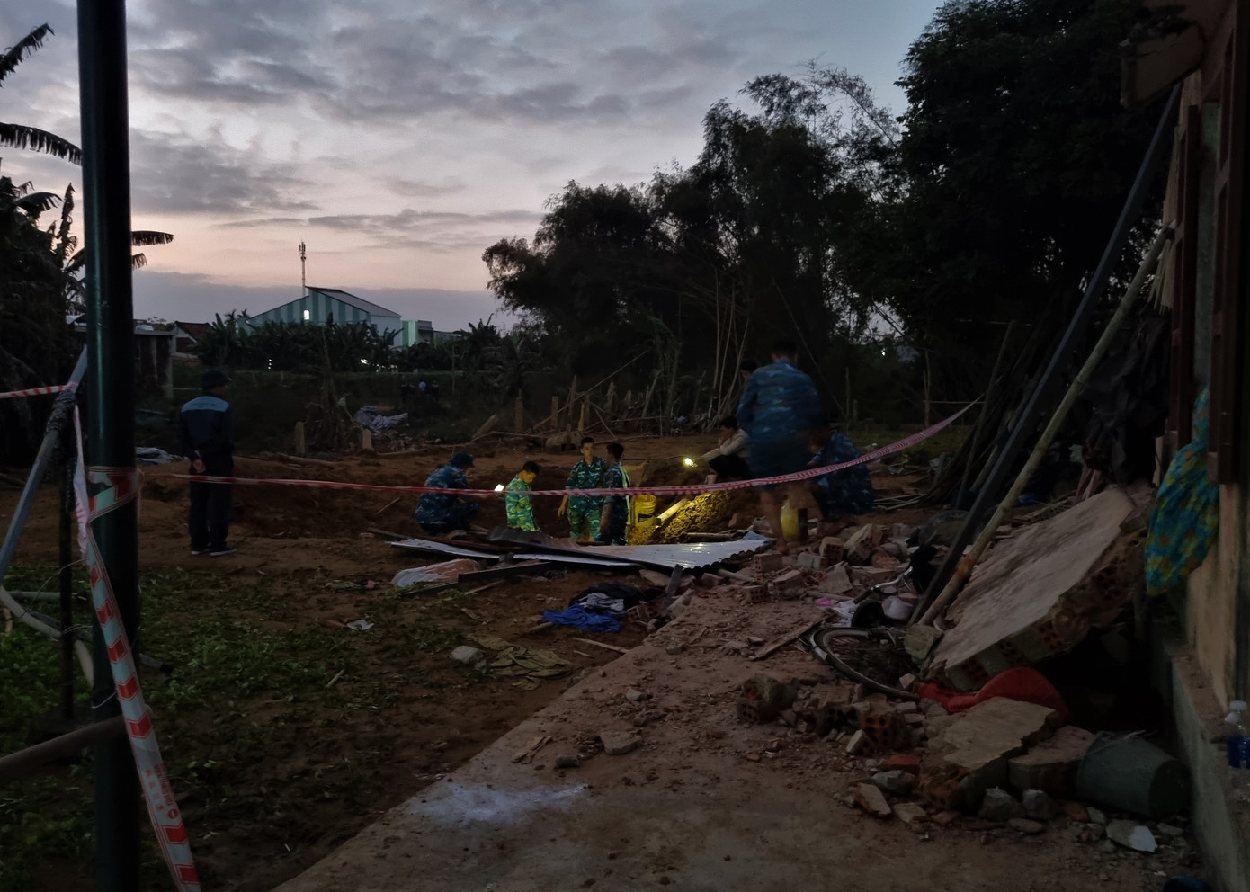 Cách đó vài chục mét, một tốp chiến sĩ xới tung khu đất, rọi đèn pin tìm kiếm mảnh vỡ máy bay. (Ảnh: Thanh Trần).