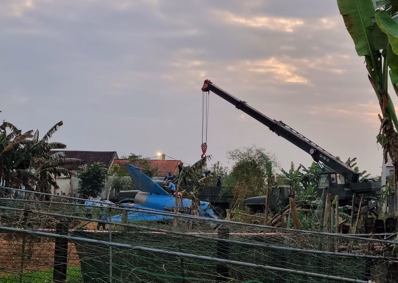Khi phi công báo máy bay gặp sự cố, không thể về hạ cánh được, chỉ huy bay lệnh cho phi công cố gắng đưa máy bay ra khỏi khu đông dân cư và nhảy dù. Đại úy phi công Đỗ Tiến Đức đã nỗ lực đưa máy bay ra xa khu dân cư và nhảy dù an toàn. Trong ảnh: Phần đuôi máy bay nằm ngay khoảng đất trống, xung quanh là nhà dân. (Ảnh: Thanh Trần). Khi phi công báo máy bay gặp sự cố, không thể về hạ cánh được, chỉ huy bay lệnh cho phi công cố gắng đưa máy bay ra khỏi khu đông dân cư và nhảy dù. Đại úy phi công Đỗ Tiến Đức đã nỗ lực đưa máy bay ra xa khu dân cư và nhảy dù an toàn. Trong ảnh: Phần đuôi máy bay nằm ngay khoảng đất trống, xung quanh là nhà dân. (Ảnh: Thanh Trần).