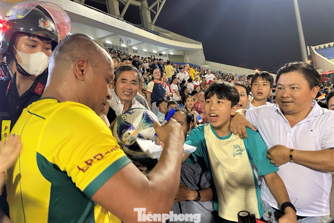 Các cầu thủ lừng danh hết sức thân thiện, nhiệt tình ký tặng trên bóng, áo và chụp ảnh với người hâm mộ sau trận đấu. (Ảnh: Thanh Hiền).