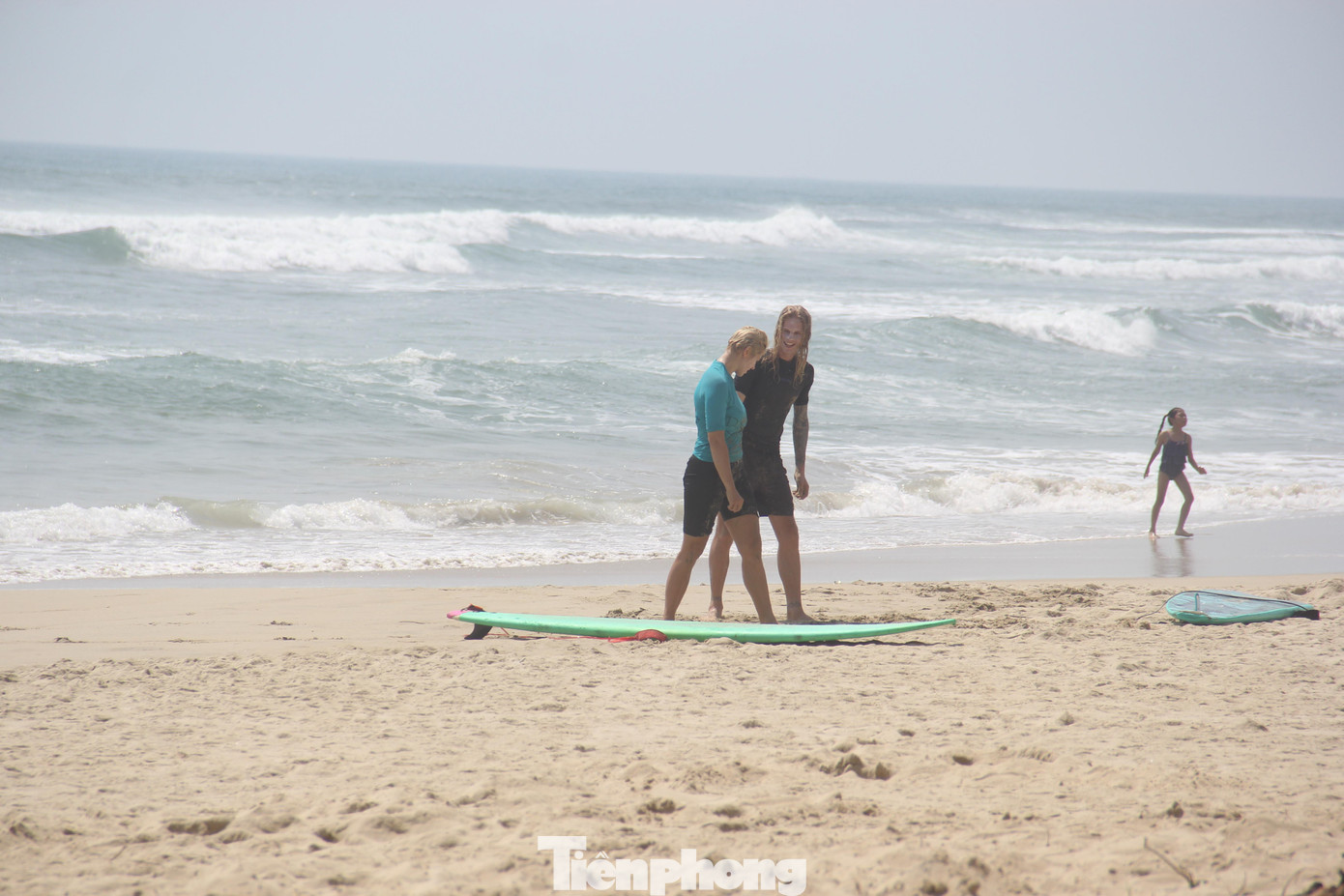 Hai du khách nước ngoài khởi động để xuống biển dù trời đã trưa. Ảnh: Thanh Trần.