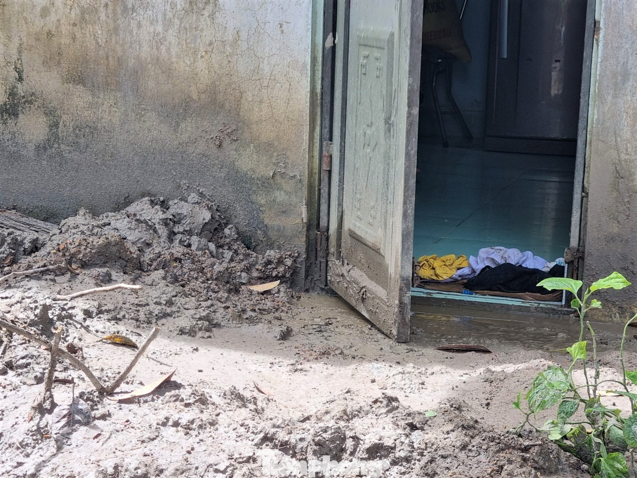 Nhà anh Ngô Phương (tổ 6) vẫn còn lấm lem, ngổn ngang, bùn đất đóng một lớp dày cộm phía cửa sau nhà. Anh kể khoảng 7h sáng 25/9, lúc đó trời đang mưa to, nước bùn từ phía CCN sau lưng nhà tuồn xuống đục ngầu. “Nước ập thẳng vô nhà, chặn mấy cũng không được. Tầm một tiếng thì lên tới mắt cá chân. Cả nhà tui hốt hoảng dọn dẹp mà không trở tay kịp, hỏng mất máy giặt, tủ lạnh, sách vở…”, anh nói. Đến khi nước rút, căn nhà anh như một thửa ruộng lấm bùn non, phía trước sân đầy đất đá.